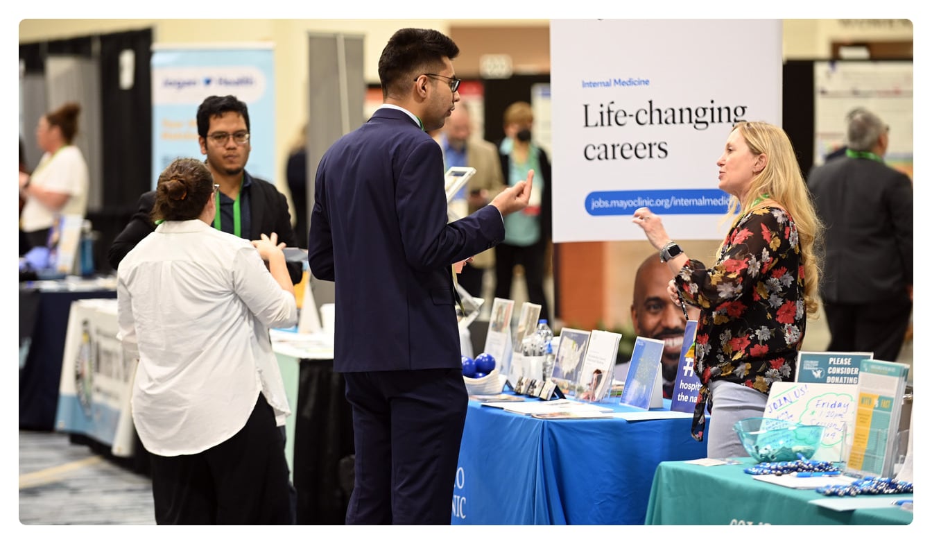 Photo of conference attendee visiting a career fair booth