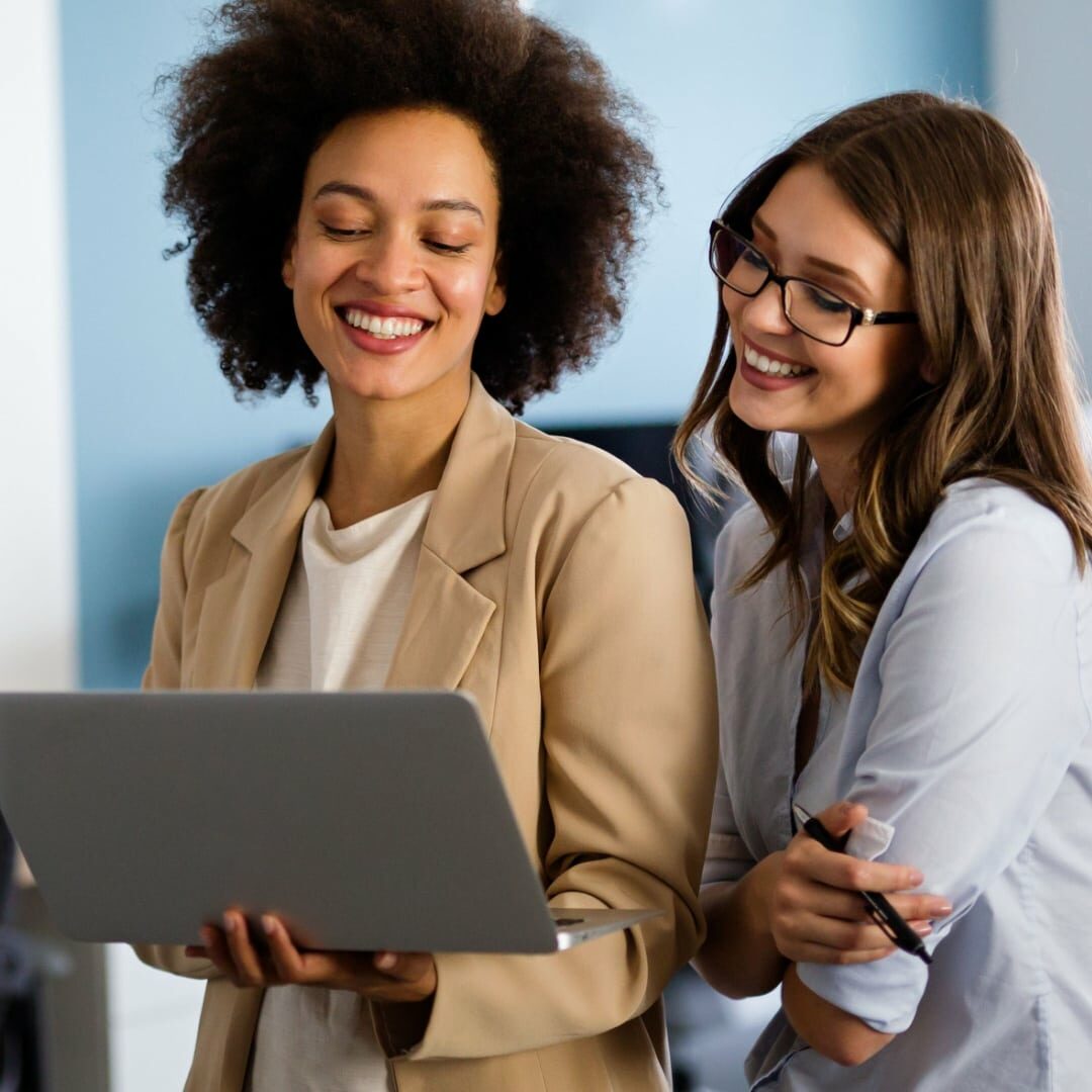 Two individuals holding a laptop, using GIM Connect