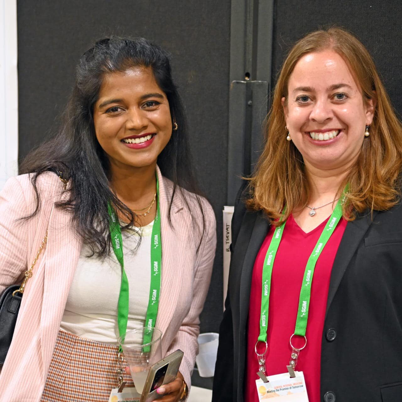 Two SGIM members wearing SGIM meeting badges posing together for a photo.