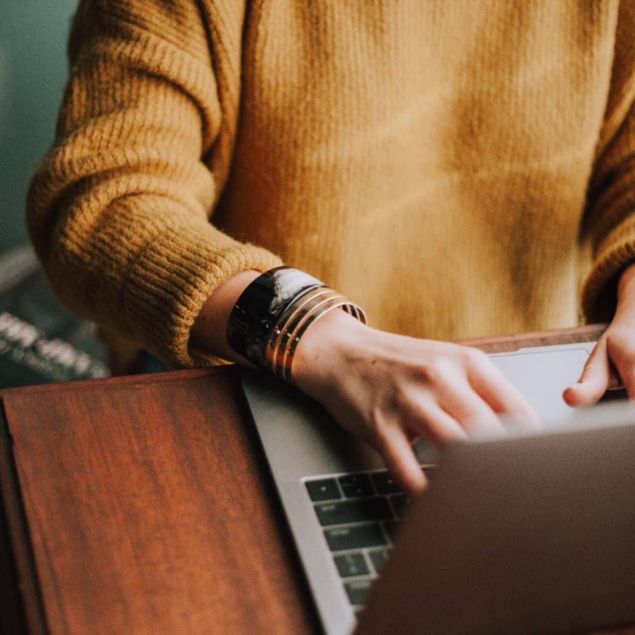 Image of hands typing on a laptop.