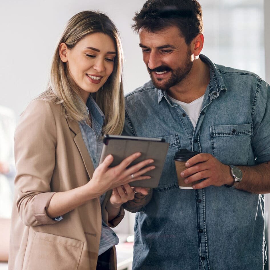 Stock image of two business professionals viewing a tablet.