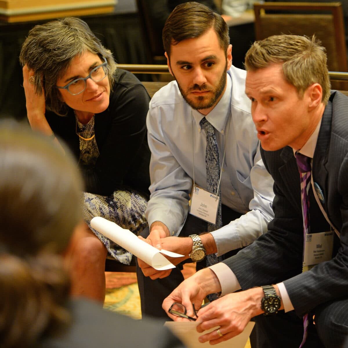 Four SGIM annual meeting attendees gathered closely in a discussion during a breakout session.