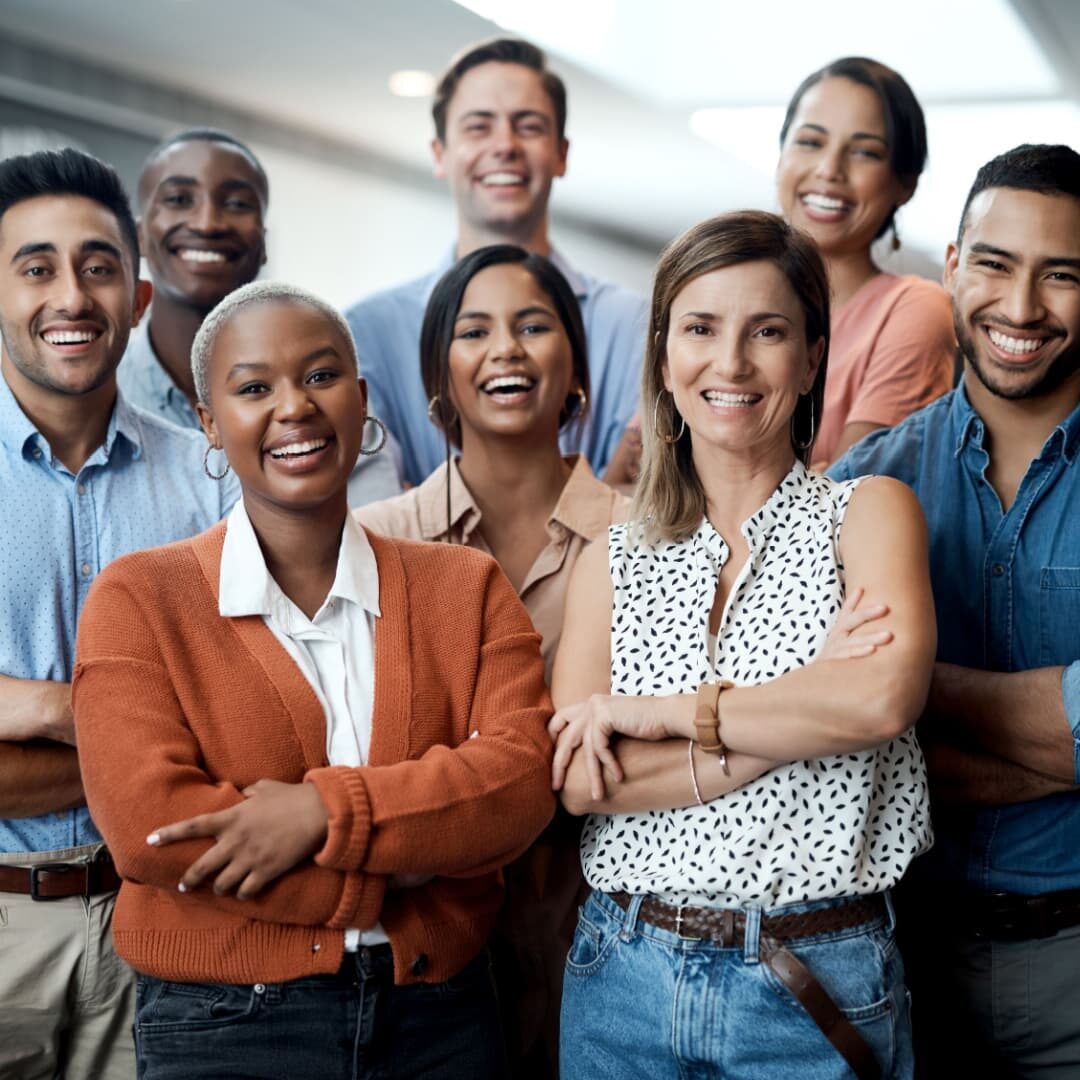 Stock image of eight corporate professionals standing together in a group, smiling.